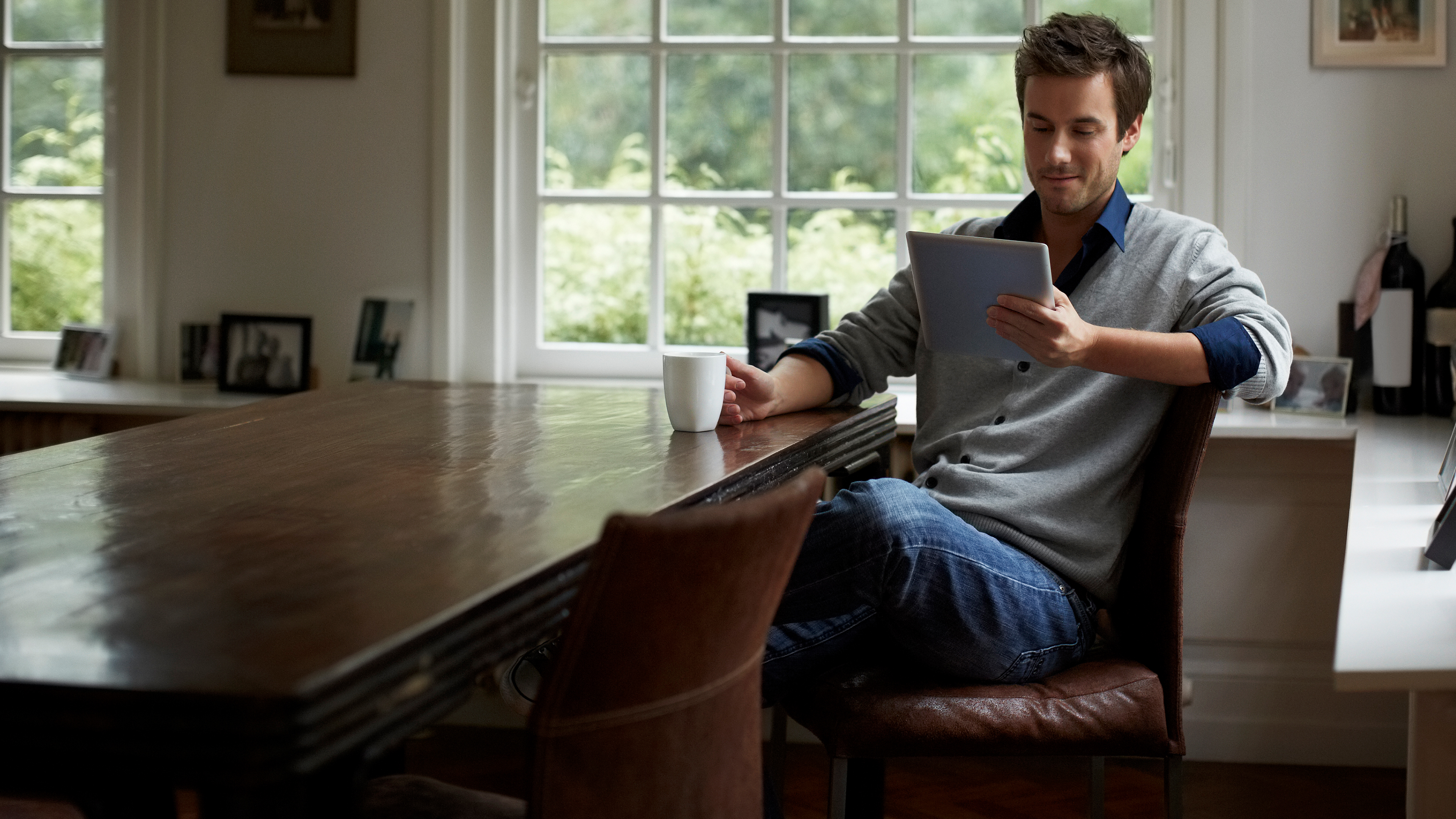 Man sitting at a table using a tablet